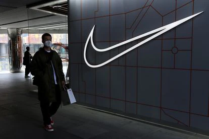 Un hombre camina junto a una tienda de Nike.