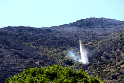 Un helicóptero protege la zona del monasterio de Sant Pere de Rodes tirando agua.