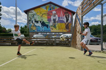 Dos niños, en un campo junto a la plaza del Ayuntamiento de Murgia, este sábado.