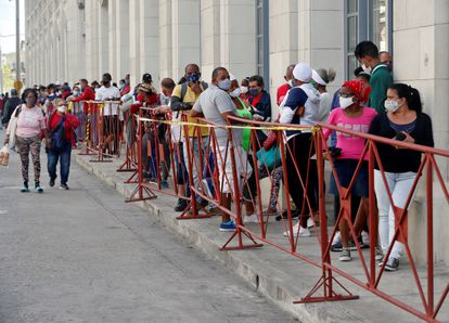 Personas con tapabocas hacen fila en febrero para comprar alimentos en un mercado de La Habana.
