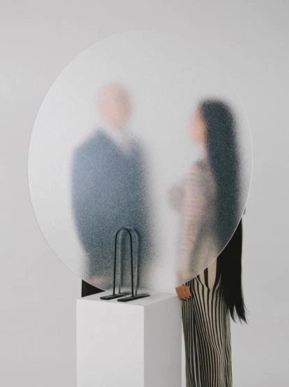 Tras el cristal, Alaska viste un vestido marinero Jean Paul Gaultier y Nacho Canut lleva un traje Prada.