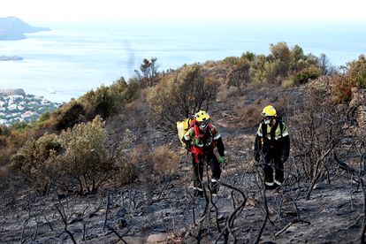 Dos bomberos en un bosque quemado en el incendio de Llançà, en Girona.