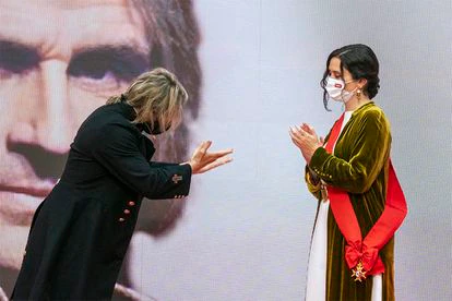 Isabel Díaz Ayuso entrega la Gran Cruz de la Orden del Dos de Mayo a Nacho Cano, que ha decidido cedérsela a la presidenta madrileña.