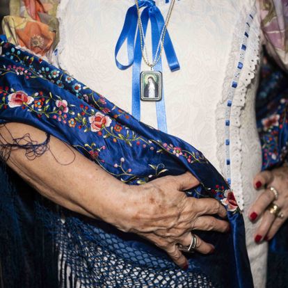 Collar con la imagen de la virgen de la Paloma, en el vestido de Araceli Lorenzo junto con su mantón de manila. DAVID EXPÓSITO
