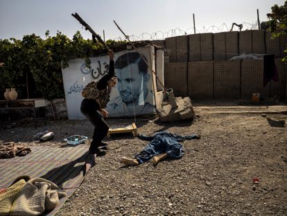 Un soldado afgano golpea el cuerpo sin vida de un talibán ametrallado, en Kandahar el 10 de agosto.