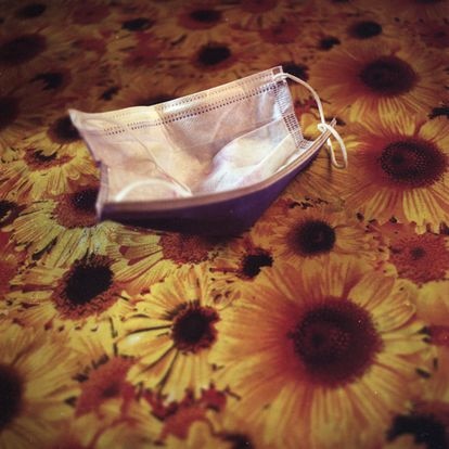 Un tapabocas yace sobre una mesa mientras su dueña toma un café de un negocio de comida en San Antonio de Los Altos.