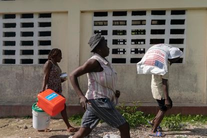 Un grupo de personas corre para recibir alimentos.
