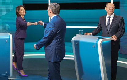 Annalena Baerbock, líder de los Verdes, saluda con un choque de puños al candidato de la CDU-CSU, Armin Laschet, junto al ministro de Finanzas y aspirante socialdemócrata a la cancillería, Olaf Scholz, en el primer debate a tres antes de las elecciones.