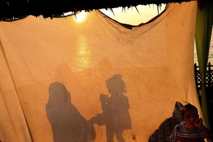 Una mujer da de comer a su hija en una tienda en Gaza, este domingo.