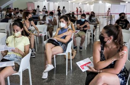 Varios jóvenes esperan tras ponerse la primera dosis de la vacuna contra el coronavirus en Valencia.