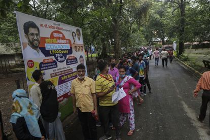 Un grupo de personas hace cola para vacunarse contra la covid-19 en la puerta de un centro de vacunación en Mumbai, India, el martes 17 de agosto de 2021.