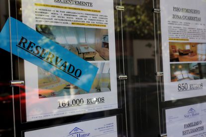 Anuncios de pisos y casas en venta y alquiler en el escaparate de una inmobiliaria en Madrid.