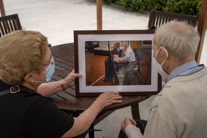 Agustina Cañamero y Pascual Pérez miran, en la residencia donde viven en Barcelona, la fotografía que les tomó Emilio Morenatti en su reencuentro tras 102 días sin verse por la pandemia.