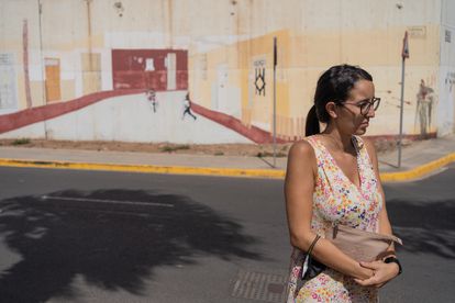 Sheyma Mohamed fotografiada frente a la pintura en la pared del presidio de Melilla, una creación obra de los propios internos que imita el aspecto de una calle.