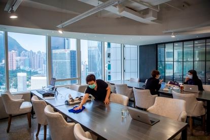 Un empleado limpia un espacio de 'coworking' en Hong Kong.
