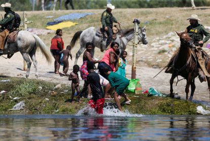 Agentes de la patrulla fronteriza de Estados Unidos cortan el paso a migrantes solicitantes de asilo que intentan regresar a Estados Unidos por el río Grande.