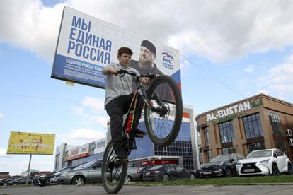 Un niño pasa en bicicleta ante un cartel electoral de Rusia Unida con un retrato de líder checheno Ramán Kadírov, este martes en Grozni.