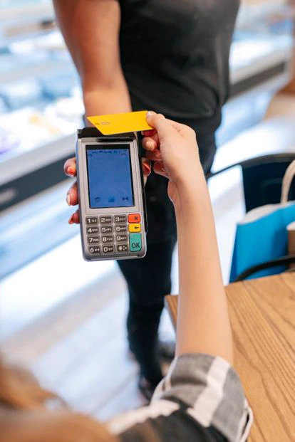 Una mujer realiza una compra con su tarjeta de crédito.