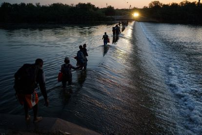 Un grupo de migrantes haitianos cruzan el Río Bravo para obtener alimentos y suministros cerca del puerto de entrada Del Río-Acuña en Ciudad Acuña, estado de Coahuila, México.