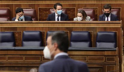 El presidente del Gobierno, Pedro Sánchez (de espaldas), y al fondo a la derecha, el líder del PP, Pablo Sánchez, en una sesión de control al Gobierno en junio.