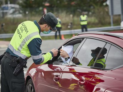 Un agente de la Guardia Civil de Tráfico comprueba la documentación de un conductor en un control policial en el límite provincial entre Navarra y Álava en 2020.