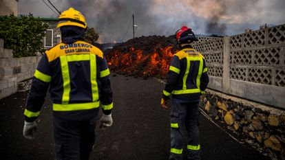 Bomberos cerca de la zona por la que avanza la lava en la isla de La Palma, este lunes.