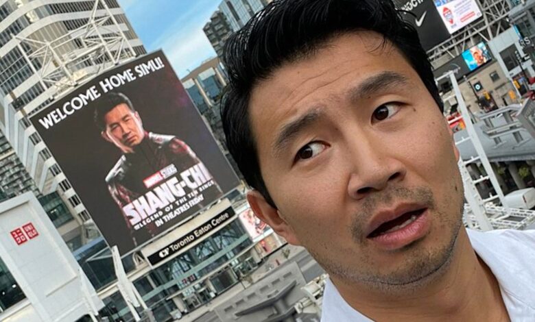 Simu Liu posa con una enorme cartelera de Shang-Chi en su ciudad natal
