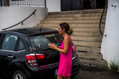 Una vecina de Todoque, este martes, junto a su coche cargado para abandonar su barrio.