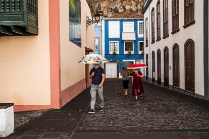 Personas con paraguas se protegen de la lluvia de ceniza en Santa Cruz de La Palma.