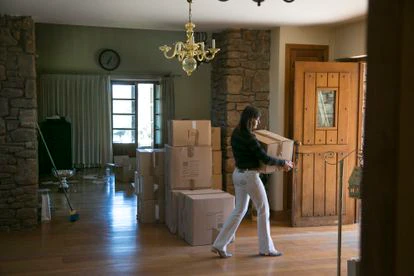 La mujer saca algunas cajas de su antigua vivienda en Torrelodones.