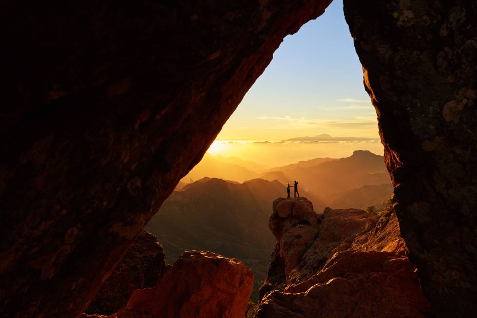 Dos senderistas en una cueva en el monumento natural de Roque Nublo, en la isla de Gran Canaria.