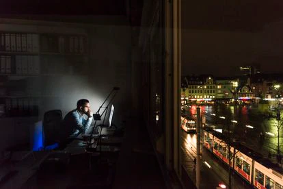 Un hombre trabajando hasta tarde en la oficina. Una estampa que empieza a debatirse en la política: muchos partidos consideran que la reducción de horas y días de trabajo puede ser una solución para abordar problemas acuciantes como la contaminación.