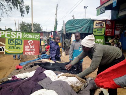 Nancy Gakii trabaja en su puesto de ropa al aire libre en el barrio chabolista de Kibera.