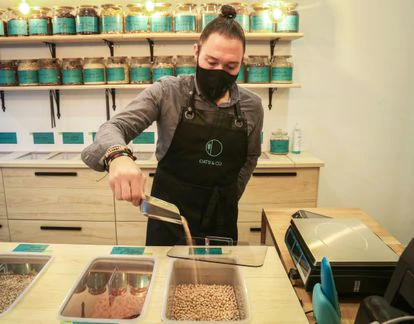 Iván Garzón vende legumbres y cereales a granel en su puesto del Mercado de Barceló, Oats & Co.