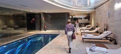 Dos mujeres caminan junto a la piscina interior de Lagasca 99.