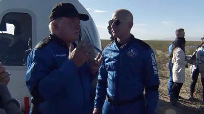 El actor William Shatner, a la izquierda, habla con Jeff Bezos al bajarse de la nave espacial cerca de Van Horn, Texas.
