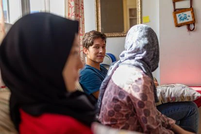 Hujjat, junto a dos de sus hermanas, en el piso de acogida donde viven en Andalucía.