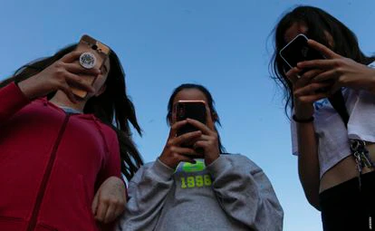 Un grupo de amigas con sus teléfonos móviles.