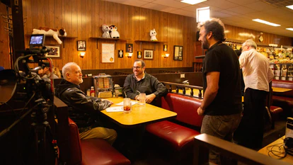 El cineasta Mark Fraga (derecha, de pie), ante Matt Zoller Seitz (izquierda, sentado) y Alan Sepinwall (centro, sentado), autores del libro 'The Sopranos Sessions' en el restaurante Holsten’s.