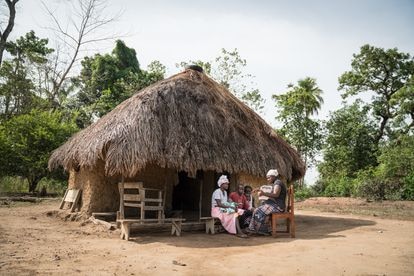 Un trabajador de salud comunitario se reúne con Kankay Suma (izquierda) y Amara Turay en la comunidad de Masiaka, distrito de Kambia, Sierra Leona, para brindar servicios básicos de salud mental y apoyo psicosocial a familias con hijos a su cargo. Pincha en la imagen para ver la fotogalería completa.