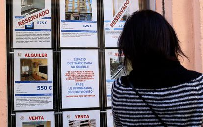 Una mujer mira el escaparte de una inmobiliaria en Valencia, en una imagen de archivo.