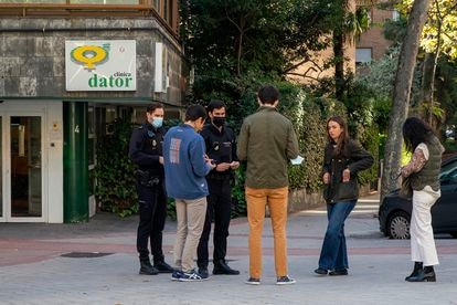 La policía identifica a personas frente a la clínica Dator en Madrid.