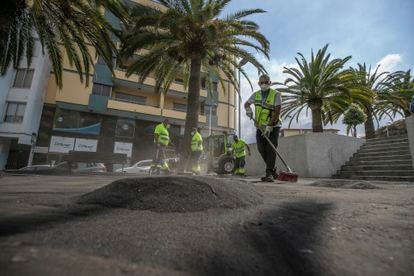 Un equipo de limpieza procedente de Tenerife limpia la ceniza procedente del volcán en una plaza de Los Llanos.