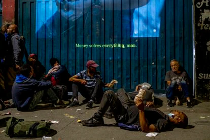 Varios habitantes de calle comparten palomitas en la proyección de 'Los días de la ballena'.