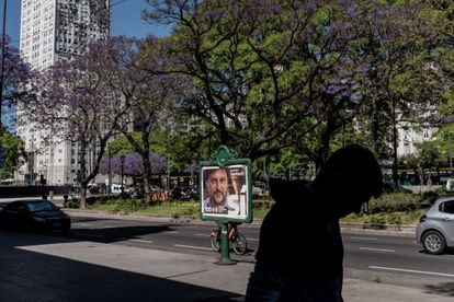 Un transeúnte pasa frente a uno de los carteles de propaganda electoral.