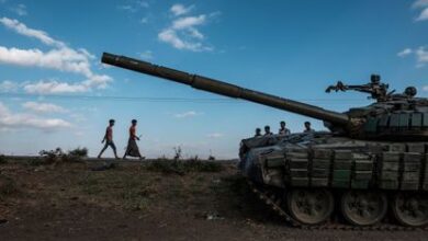 Varios jóvenes caminan junto a un tanque de los rebeldes tigrayanos abandonado cerca de Mehoni, en la región etíope de Tigray, el 11 de diciembre de 2020.