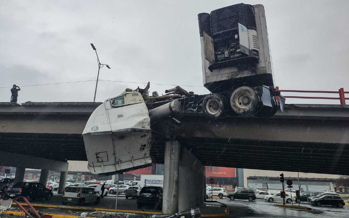 Tráiler choca y queda colgado de paso a desnivel en Nuevo León