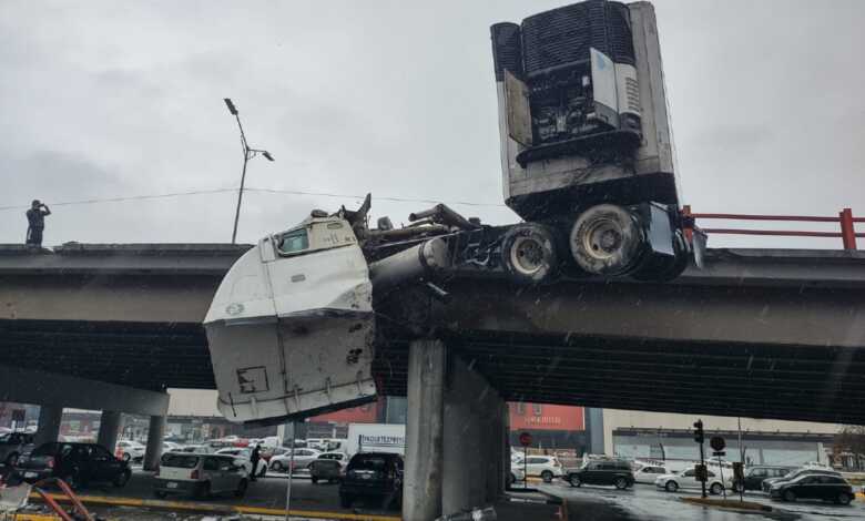 Tráiler choca y queda colgado de paso a desnivel en Nuevo León