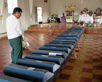 Un hombre se encuentra frente a los ataúdes de víctimas de la masacre de El Mozote, Morazán, El Salvador, en diciembre de 2000.