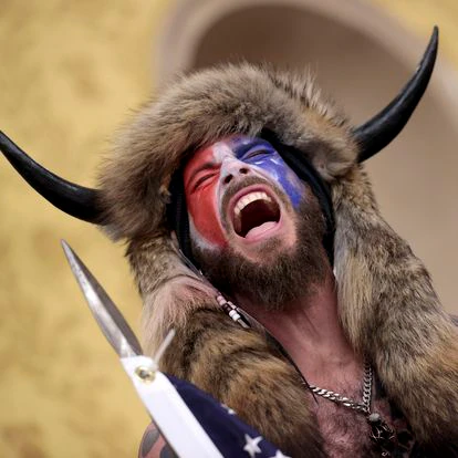 WASHINGTON, DC - JANUARY 06: A protester screams "Freedom" inside the Senate chamber after the U.S. Capitol was breached by a mob during a joint session of Congress on January 06, 2021 in Washington, DC. Congress held a joint session today to ratify President-elect Joe Biden's 306-232 Electoral College win over President Donald Trump. A group of Republican senators said they would reject the Electoral College votes of several states unless Congress appointed a commission to audit the election results. Pro-Trump protesters entered the U.S. Capitol building during demonstrations in the nation's capital. (Photo by Win McNamee/Getty Images)